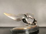 statue of a flying bird on a black base on a black surface