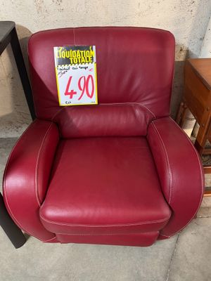un fauteuil inclinable en cuir rouge sur lequel est accrochée une étiquette de prix