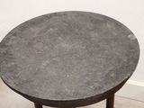 a small round table with a black top on the floor