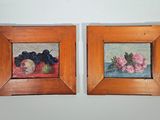 deux tableaux encadrés représentant des fruits et des fleurs sur un mur blanc
