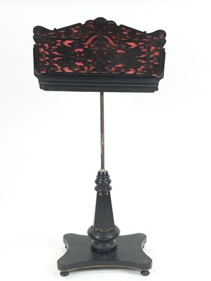 une photo d'une lampe de table noire et rouge posée sur un pied