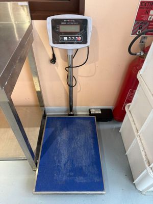 une balance posée par terre dans une pièce