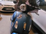 a blue scooter parked in a garage next to a white car