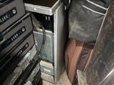 a pile of electronics and a suitcase in a room