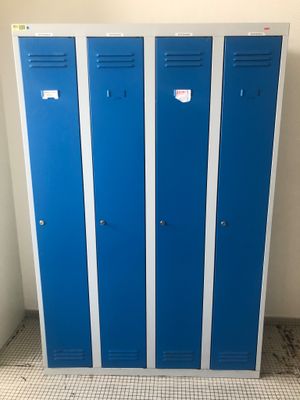 trois casiers bleus dans une pièce au sol carrelé et aux murs blancs