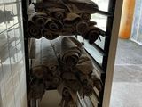 several rolls of towels stacked on a rack in a room