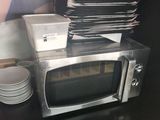 un micro-ondes posé sur une table sur laquelle se trouvent des assiettes