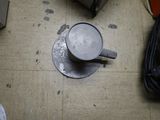 a coffee cup sitting on the floor next to a suitcase