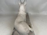 statue of a dog laying down on a block of concrete
