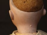 a doll head with a muffin on top of it