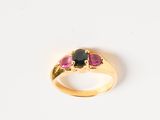 an image of a gold ring with a black and pink stone