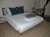 a bed with white sheets and pillows on it in a room
