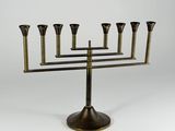 an antique brass menorah with five candles on a stand
