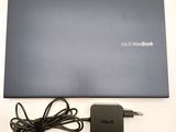 an asus laptop with a charger and power cord sitting on a table
