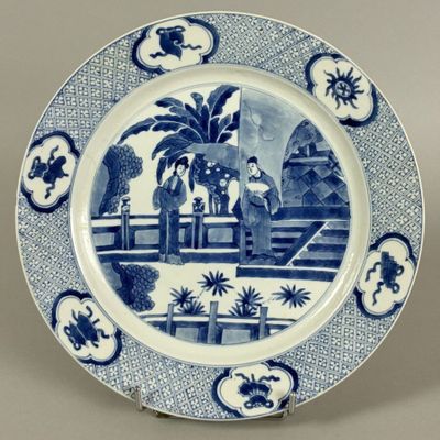 blue and white plate with a picture of a man and a woman on a bridge