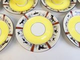 six assiettes jaunes et blanches ornées de motifs noirs et rouges