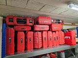 de nombreuses caisses à outils rouges posées sur une étagère dans un garage