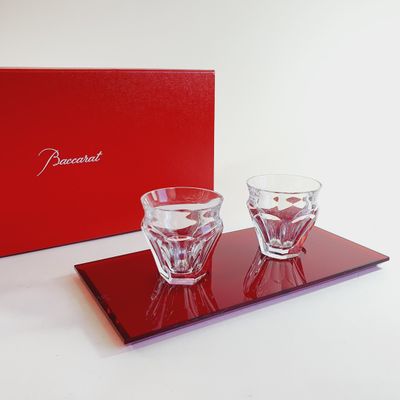 two glasses on a tray with a red box in the background