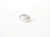 the ring is made of silver metal and has a wavy design