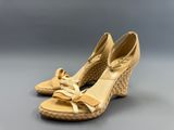 une paire de chaussures beiges avec un nœud au talon