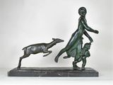 bronze statue of a woman and a dog on a marble base