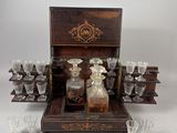 une boîte en bois contenant un service de verres et une bouteille d'alcool