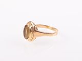 a close up of a gold ring with a brown stone