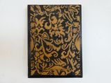 an old book with a gold and black pattern on it