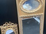 un miroir doré et un cadre doré sur fond noir
