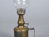 une lampe à huile à l'ancienne surmontée d'un verre