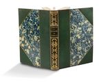 un vieux livre à la couverture verte et aux bords dorés
