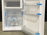 a white refrigerator with its door open on the floor