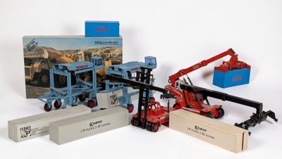 un camion jouet équipé d'une grue et d'une caisse remplie de cartons