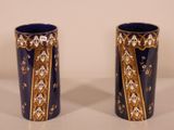 pair of blue and gold vases sitting on top of a white table