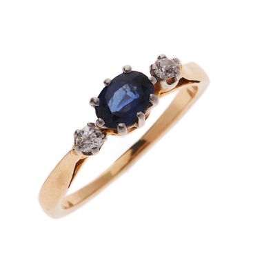 gros plan d'une bague avec un saphir et des diamants