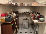 une petite cuisine où le sol est encombré d'objets