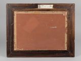 an old picture frame with a brown background and a label on it