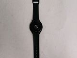 a close up of a watch on a white surface with a black strap