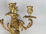 a gold candle holder with two candles on top of it