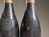 two bottles of wine sitting next to each other on top of a table