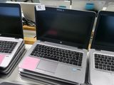 Plusieurs ordinateurs portables sont alignés sur une table dans un magasin