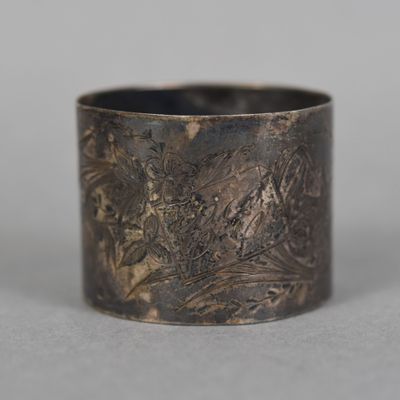 an old silver ring with a design on it on a table