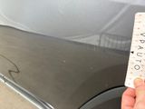 someone is holding a parking ticket in front of a parked car