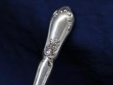 a silver spoon sitting on top of a blue cloth