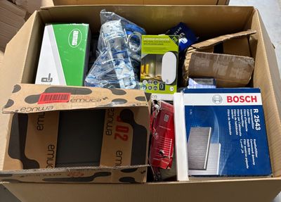 une boîte en carton remplie d'objets divers, posée par terre