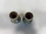 two brown vases sitting on a white surface