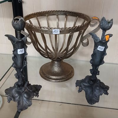 trois vases en métal posés sur une table en verre