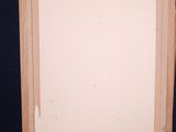 a wooden easel with a blank canvas on it against a blue background