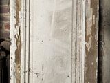 an old white door with peeling paint on it