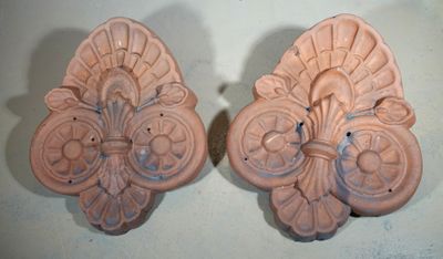 une paire d'appliques murales en céramique rose sur un fond blanc